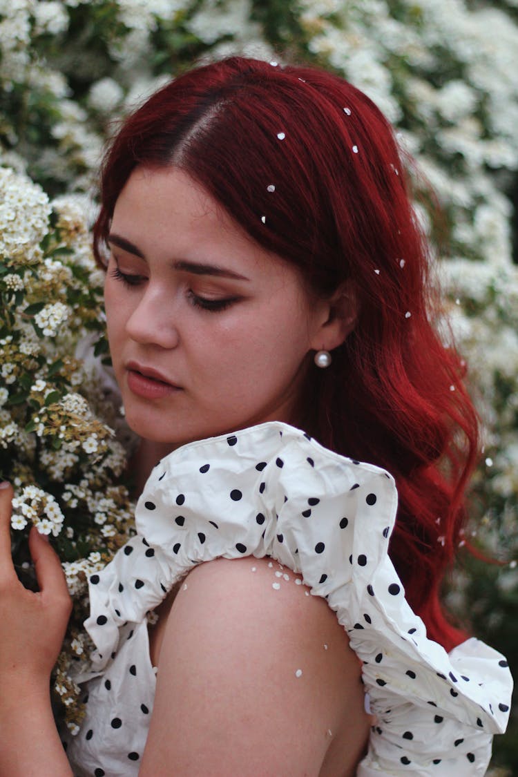 Woman In Polka Dot Blouse Beside The White Flowers