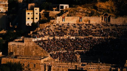 Free A bustling Roman Theatre in Amman, Jordan, filled with people during sunset, showcasing local culture. Stock Photo