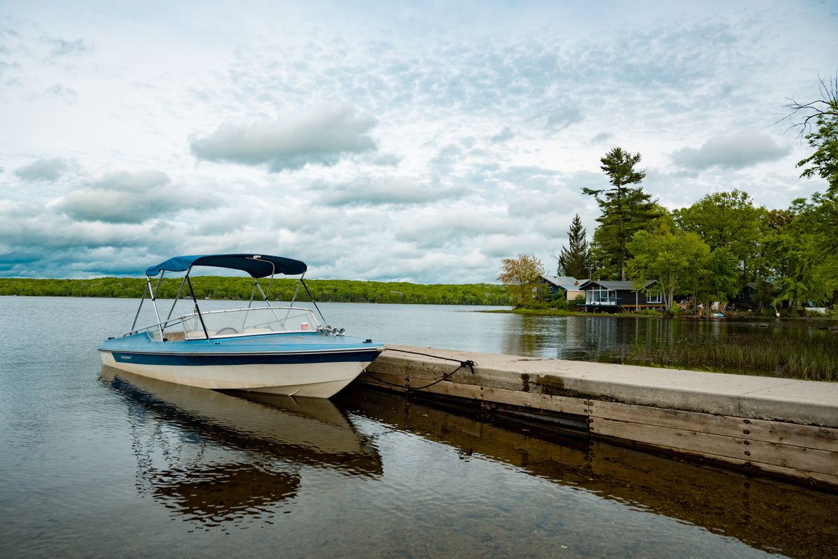 Tranquil lake scene with a moored boat and a lakehouse