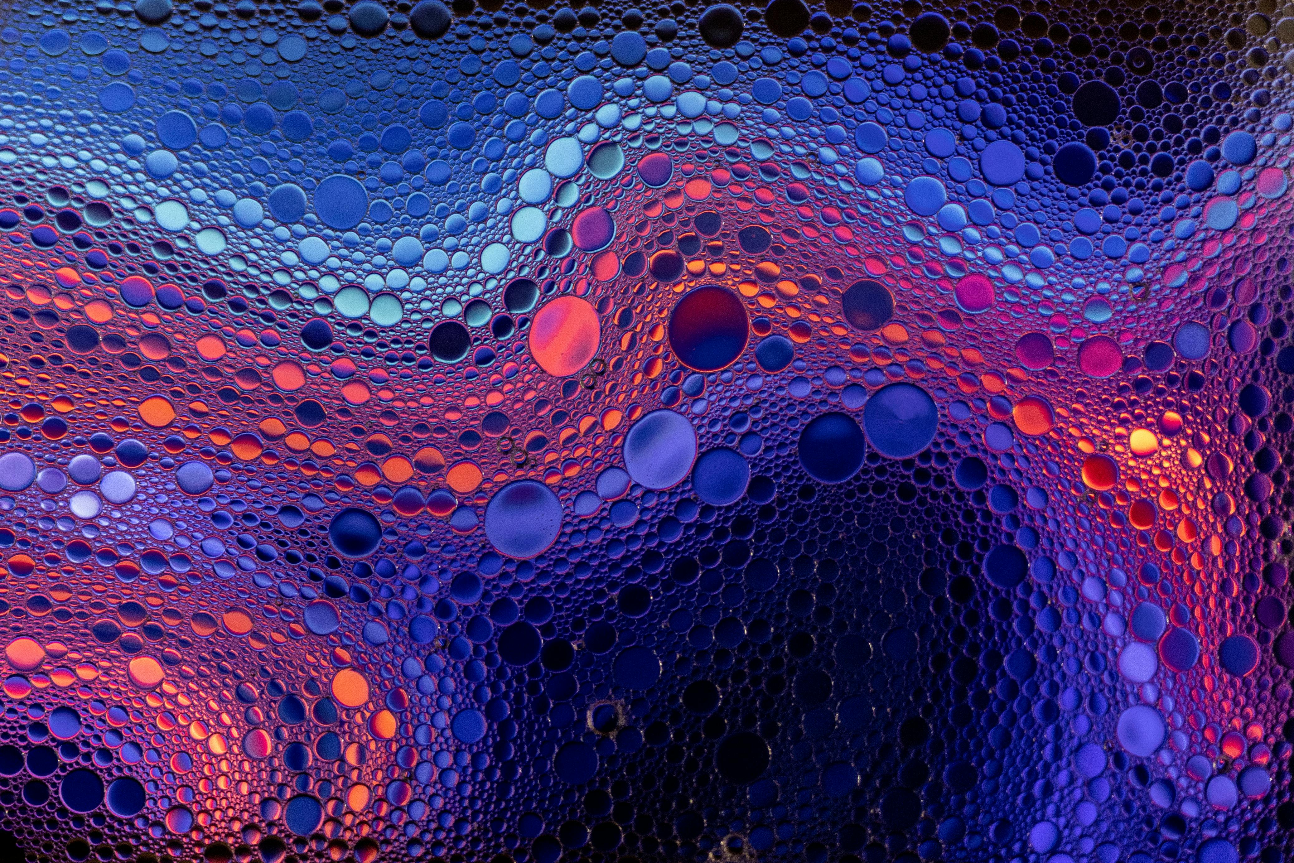 Colorful abstract pattern of bubbles with a gradient from blue to red hues, creating a dynamic visual effect.