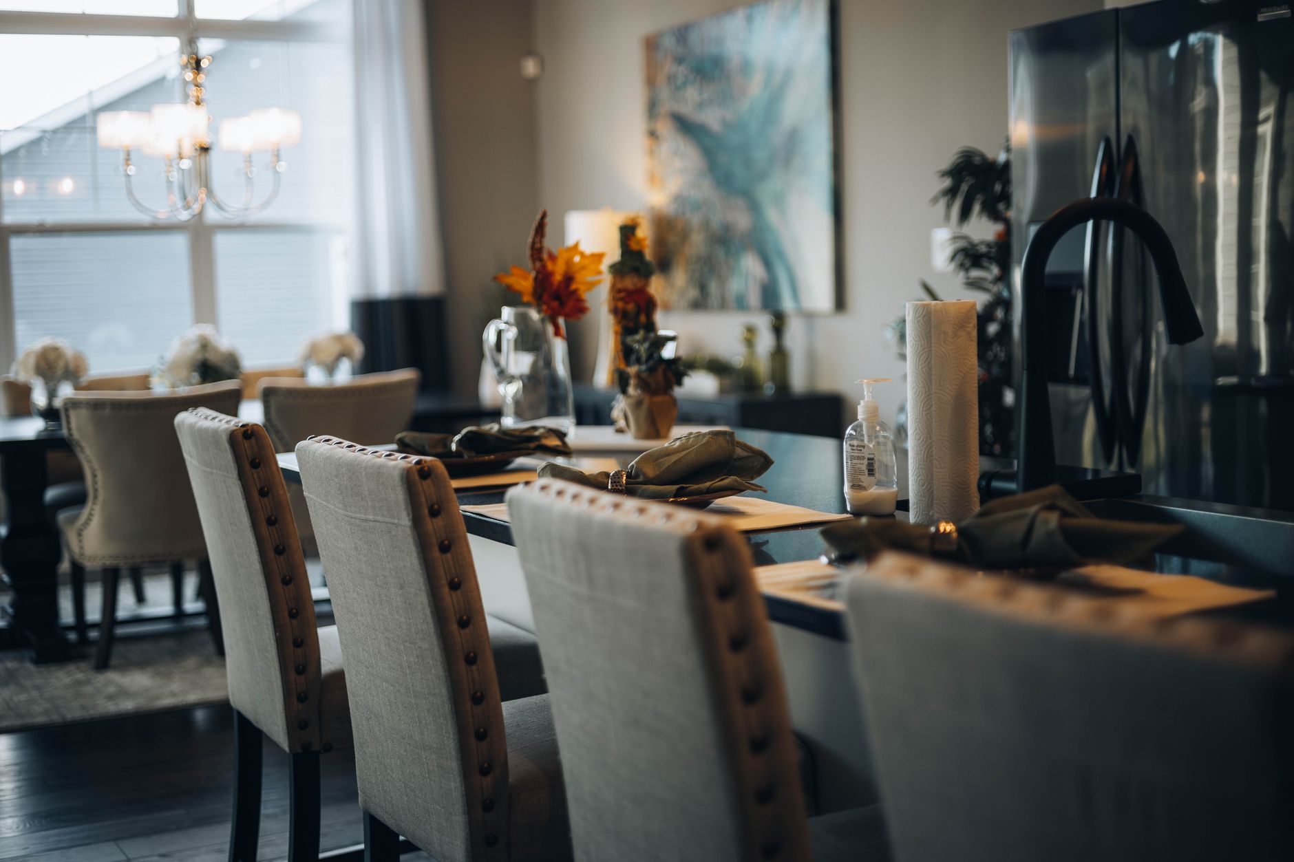 A sophisticated dining room setup with a modern table, elegant chairs, and ambient lighting.