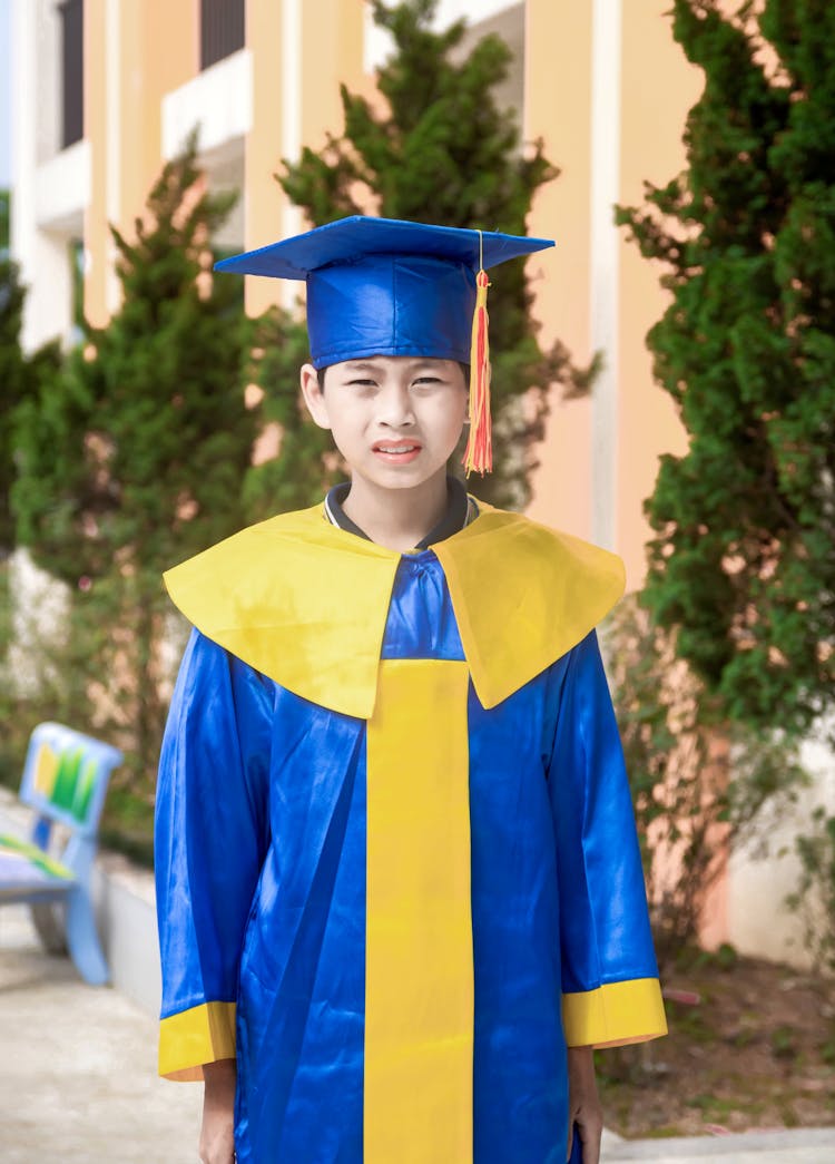 Boy Wearing Academic Dress And Graduation Cap