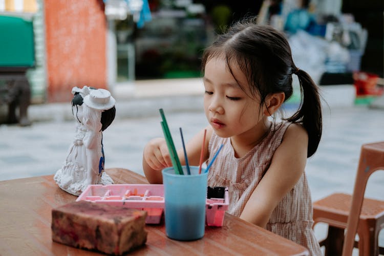 Girl Painting A Figurine