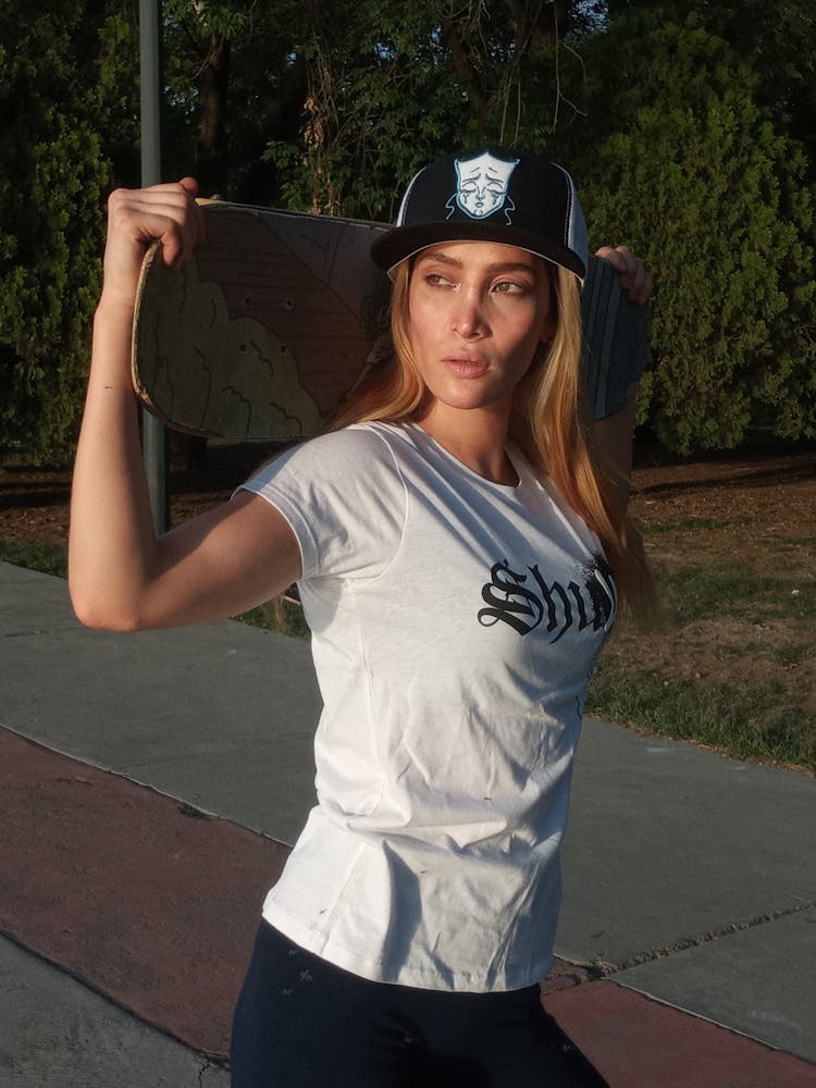 Woman In Hat Posing With Skateboard Outdoors