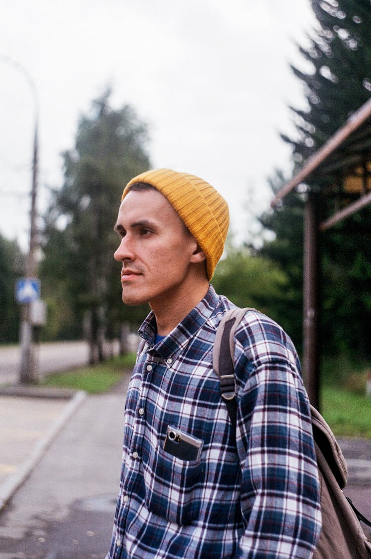 Man In Knit Hat And Checked Shirt Standing On Bus Stop