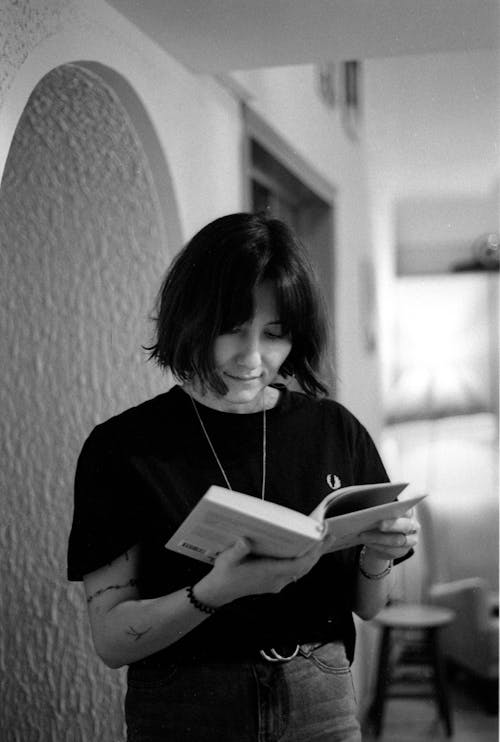 Black and White Photo of Woman Reading a Book