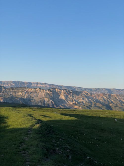 Clear Sky over Grassland and Hills with Rocks