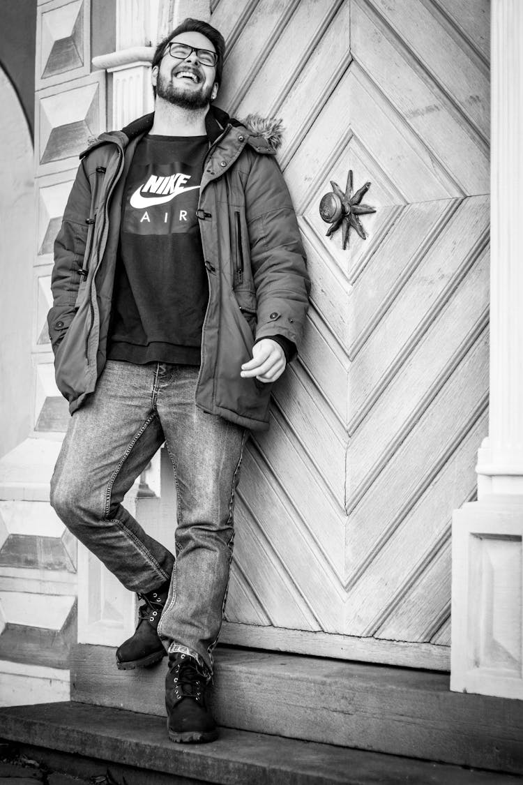 A Happy Man In Fur Jacket Leaning On The Wall