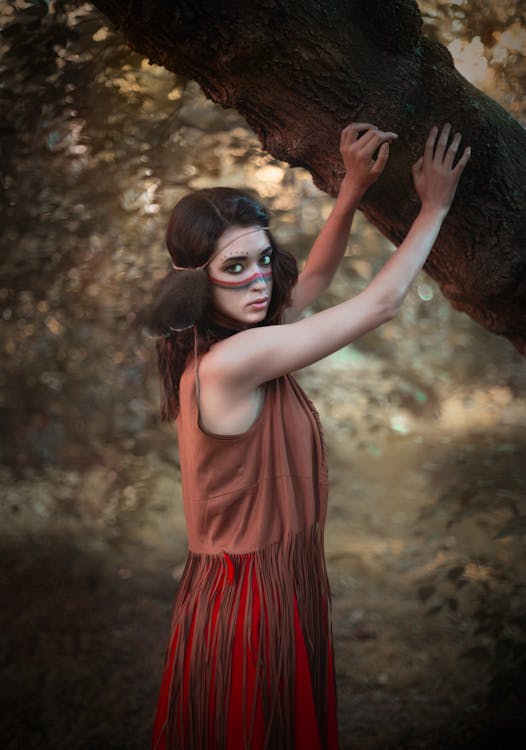 Selective Focus Photography of Woman Holding a Tree