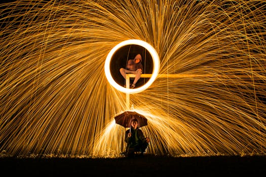 Captivating long exposure shot featuring vibrant light painting with steel wool and silhouette figures.