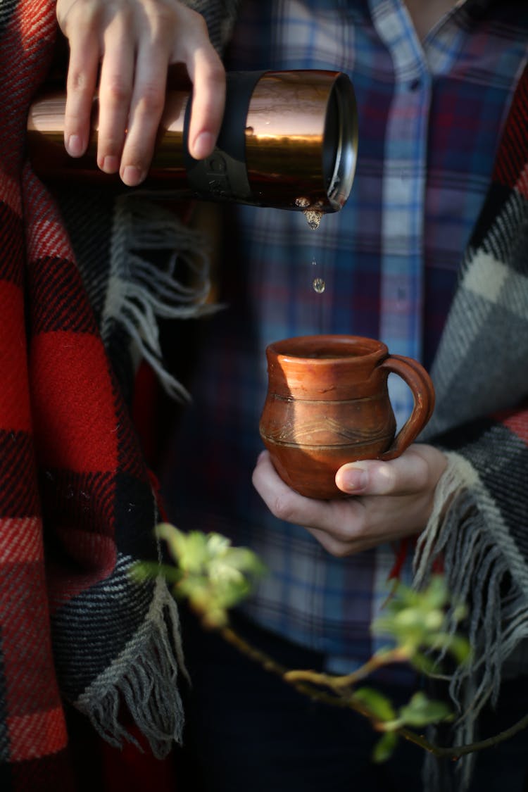 Person Pouring Water Into Cup 