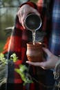 Person Pouring Water into Cup 