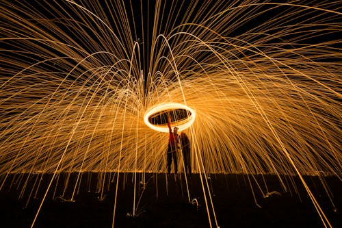 Person Standing Beside Another Person Holding Fire Poi
