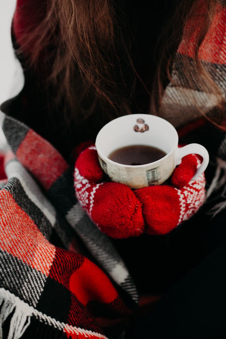 Woman Holding A Cup Of Hot Coffee Wearing Mittens 