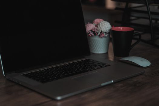 Cozy indoor workspace featuring a laptop, coffee mug, and decor elements, ideal for remote work settings.