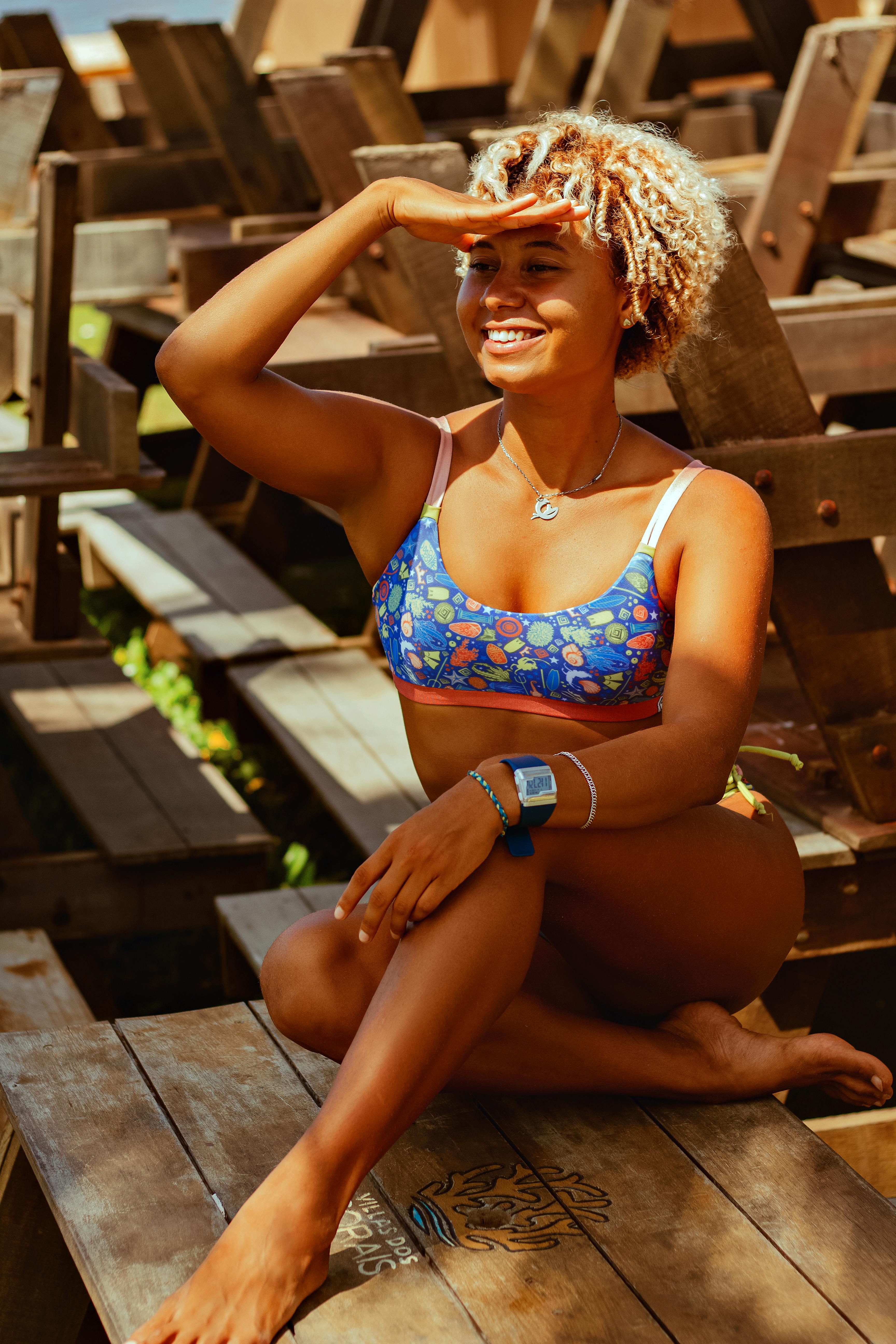 Portrait of girl wearing bikini top leaning against tree