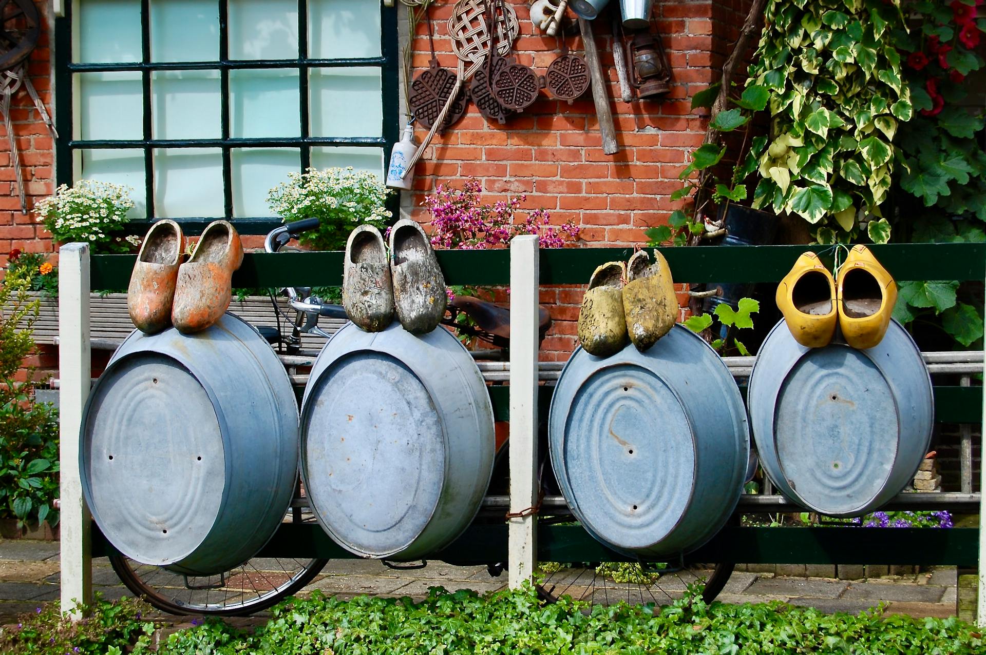 Beautiful display of Dutch clogs and galvanized tubs in a garden setting in Amsterdam.