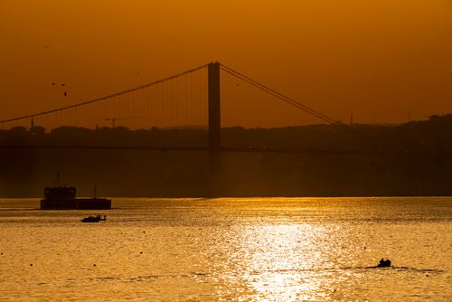 Free Scenic sunset view of İstanbul with a bridge and boats on the shimmering water. Stock Photo