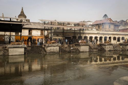 Free Traditional cremation ceremony at a riverside ghats in a historical town. Stock Photo