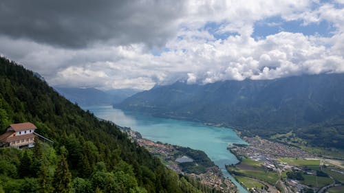 Aerial Photography of Lake between Mountains under the Cloudy Sky