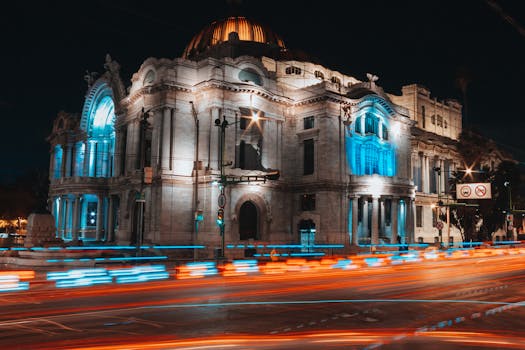 Night view of the illuminated Palacio de Bellas Artes with light trails in Mexico City.