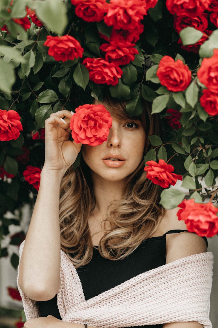 Blonde Woman Standing Under Rose Bush