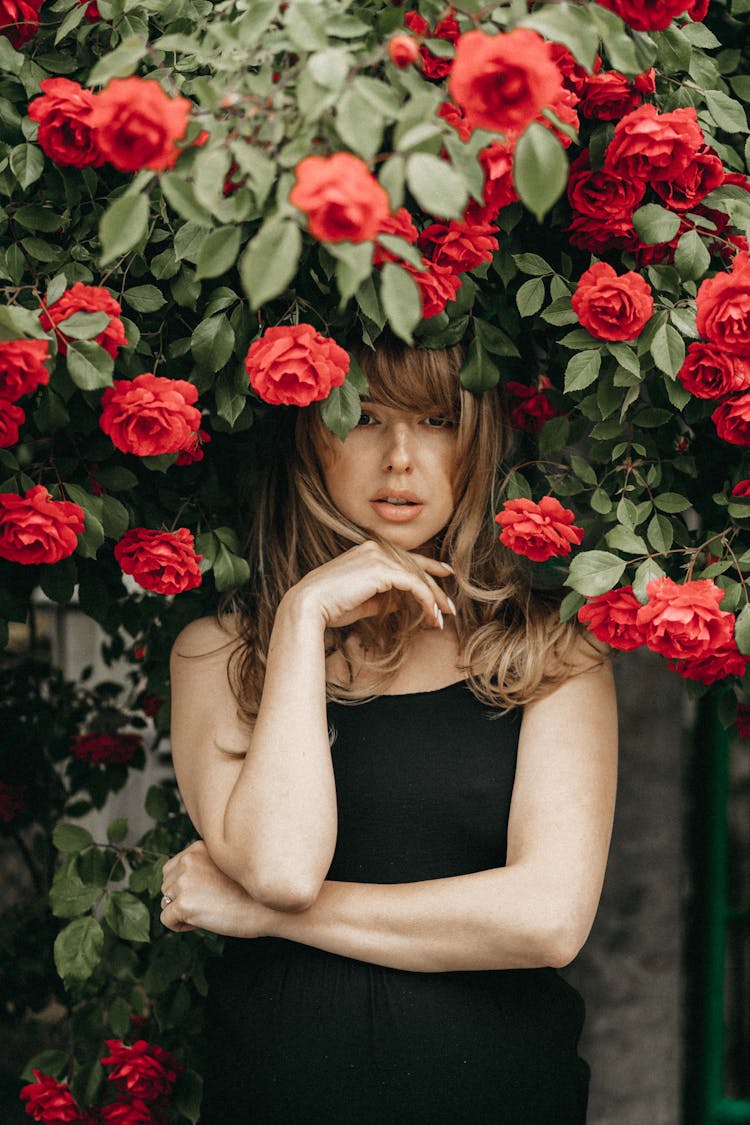 Blonde Woman Standing Under Rose Bush