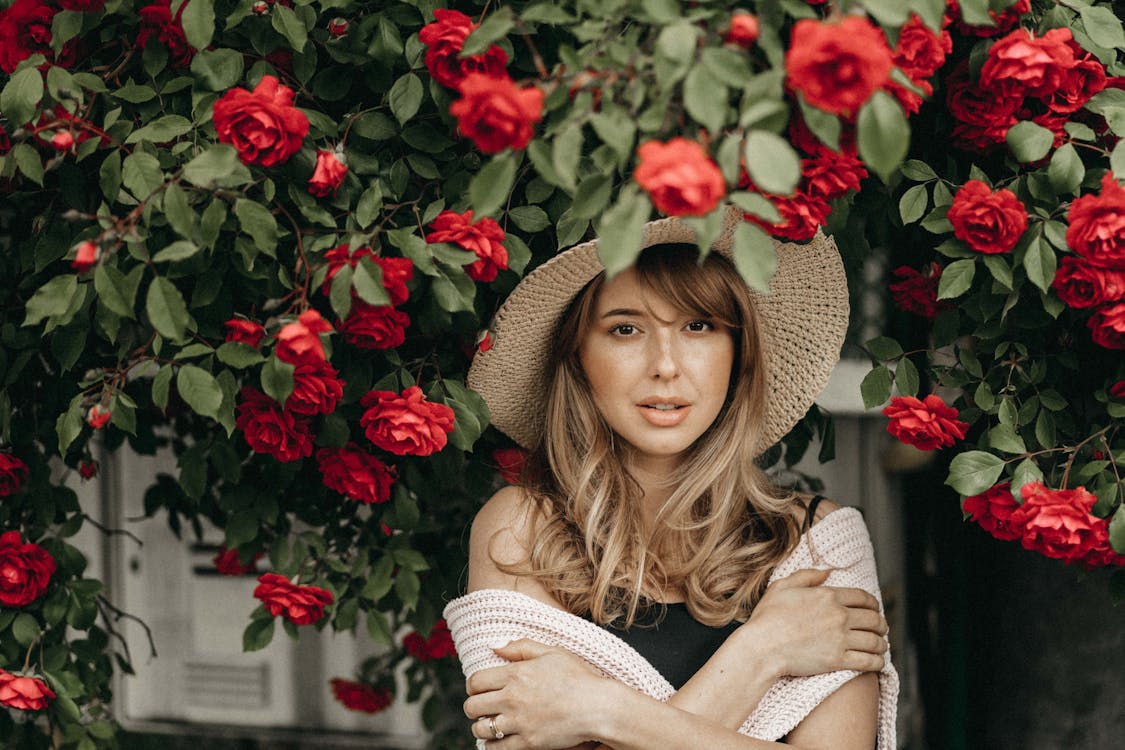 woman standing under rose bush
