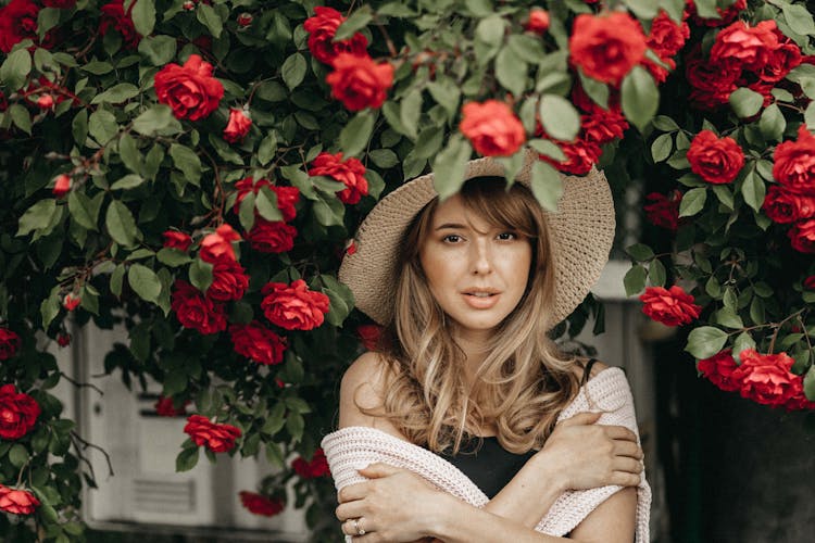 Blonde Woman Standing Under Rose Bush