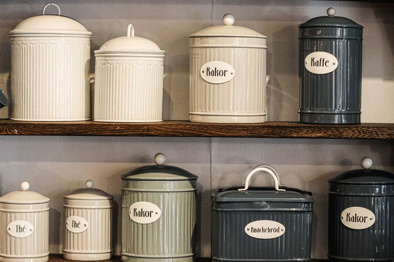 Retro-style kitchen storage jars and containers on shelves, showcasing a vintage and organized kitchen setup.