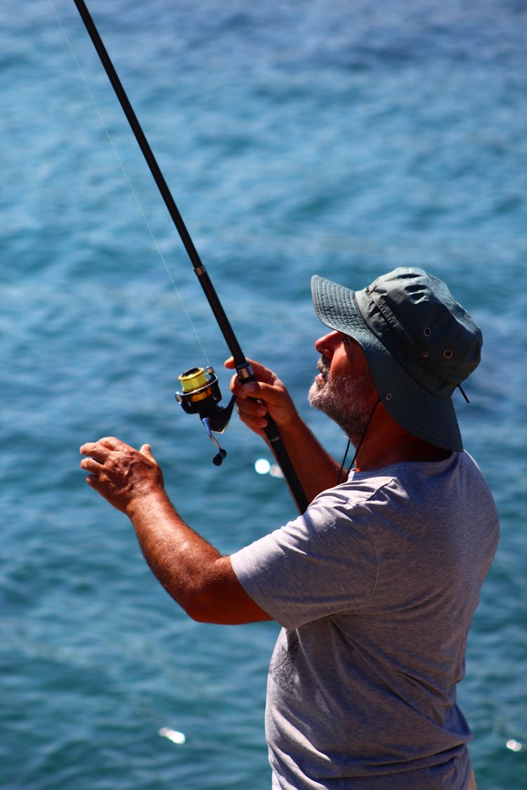 Man In Hat Fishing With Rod