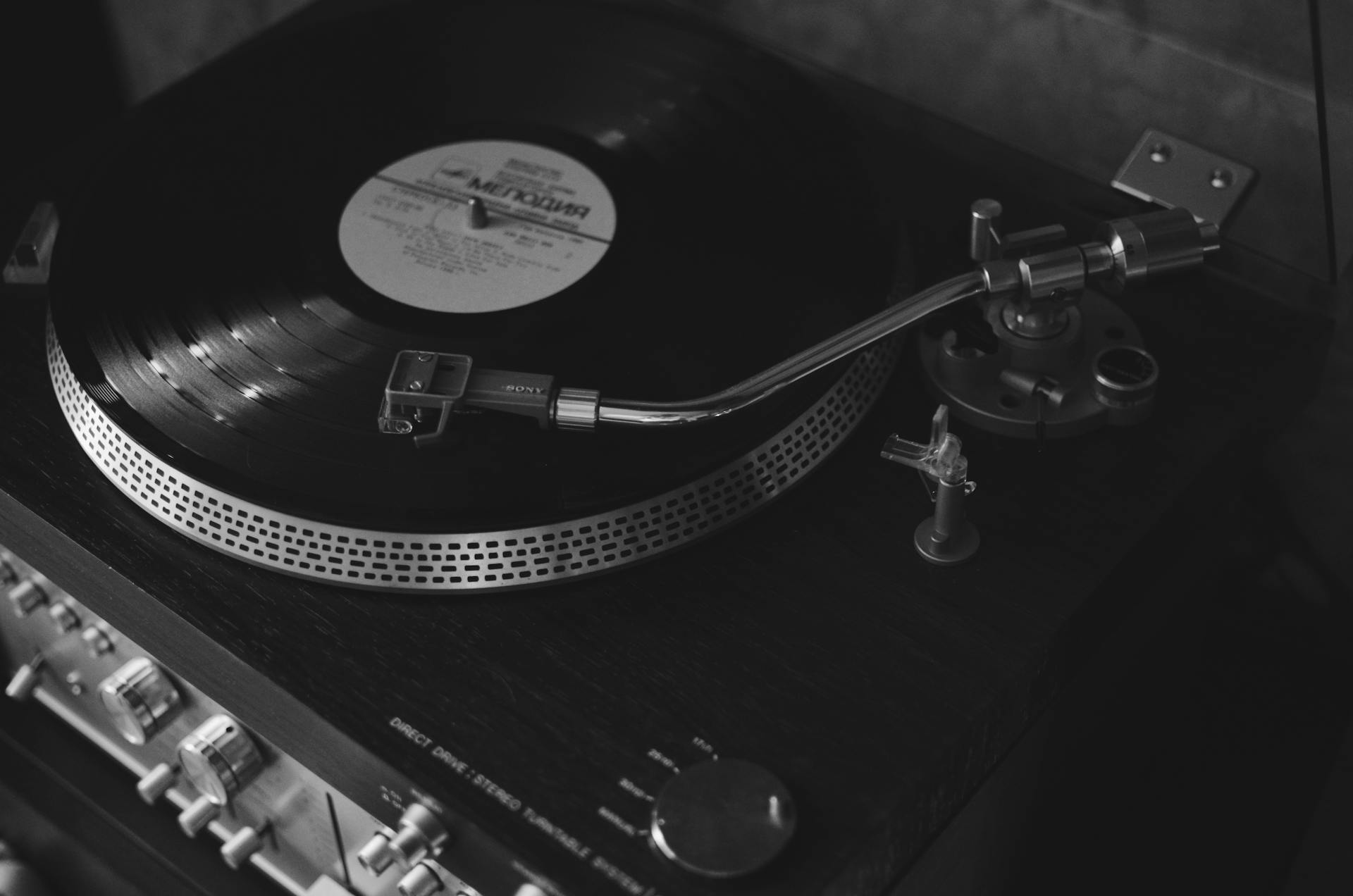 Captivating black and white image of a vintage turntable playing a vinyl, capturing the essence of retro music equipment.