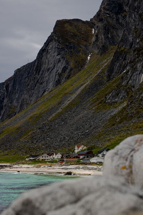 Free Explore the rugged beauty of a coastal village beneath towering cliffs in Lofoten, Norway. Stock Photo