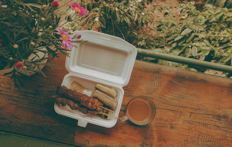 Barbecue And Sausage On Styrofoam With Coffee Mug On Table