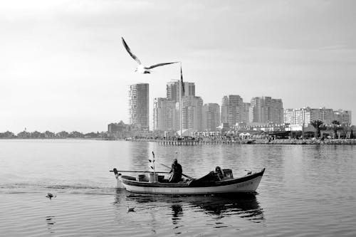 A Grayscale of Fisherman on His Boat