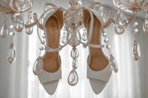 White and Brown Leather Peep Toe Sandals Hanging on Chandelier