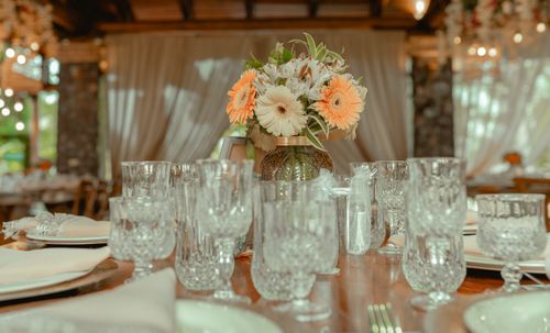 Free Crystal glassware and floral centerpiece adorn an elegant dining setup, creating a warm and festive ambiance. Stock Photo