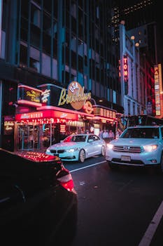 Dynamic city street at night with neon lights and bustling nightlife in New York City.