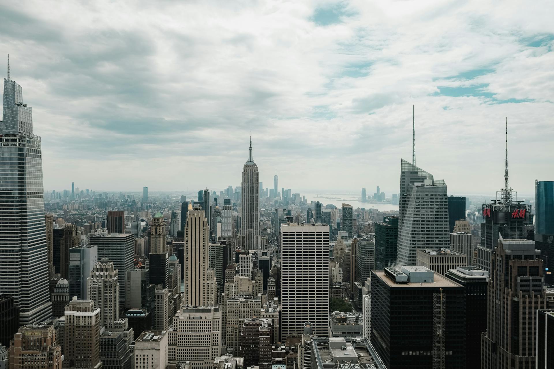 A breathtaking view of New York City's skyline featuring the iconic Empire State Building on a cloudy day.