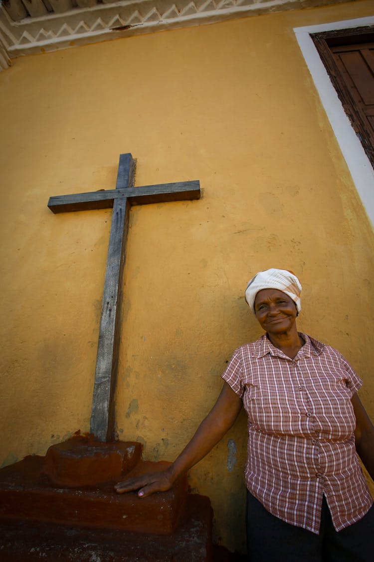 A Woman Standing Beside A Crucifix