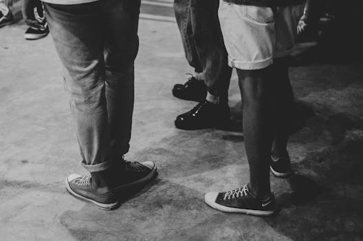 Black and white photo capturing a casual gathering, emphasizing footwear styles.