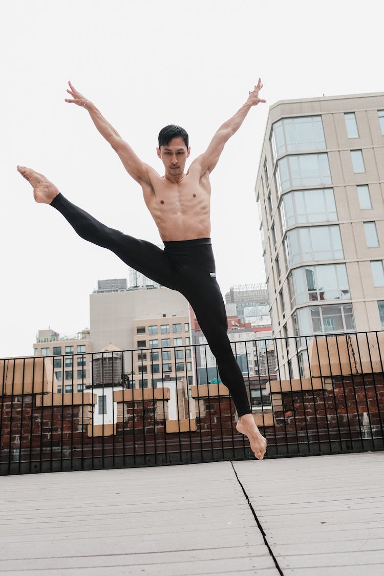 Shirtless Man In Black Leggings Dancing On Rooftop