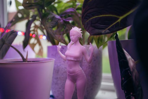 Shallow Focus of a Pink Figurine near Potted Plants