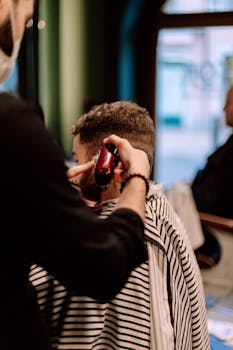 Barber giving a stylish haircut in a Geneva shop, captured in a close-up vertical shot.