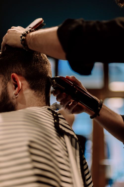 Free Close-up of a barber using clippers to style a man's hair in a Geneva barber shop. Stock Photo