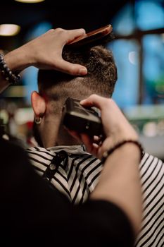 Back view close-up of a haircut in a Geneva barbershop, focusing on hairstyling tools in action.