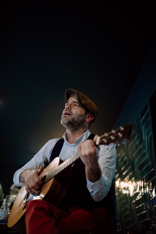 A Man Singing While Playing Guitar