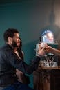 A Person Handing Out a Glass of Beer to a Man in Black Long Sleeve Shirt
