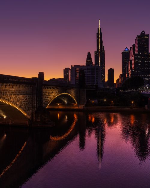 Free Stunning evening view of Philadelphia skyline with illuminated bridge and reflections. Stock Photo