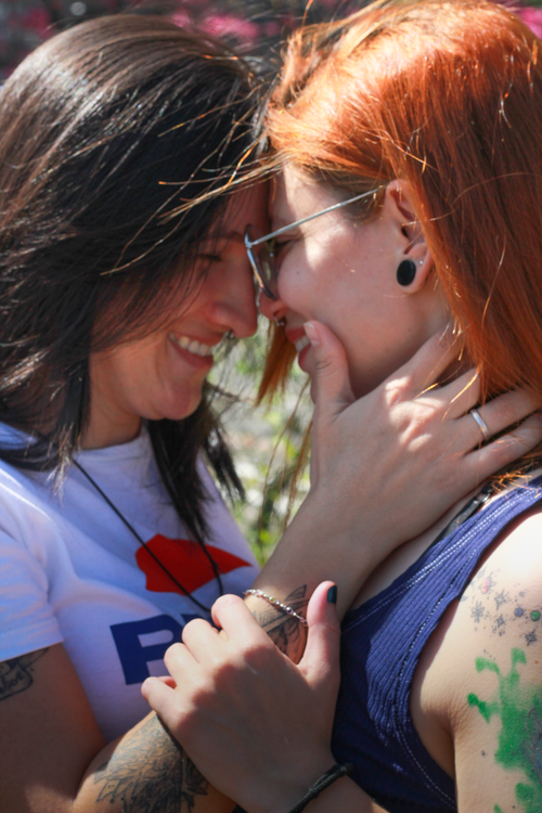Free A tender moment between two women sharing a loving embrace outdoors in sunny Brazil. Stock Photo